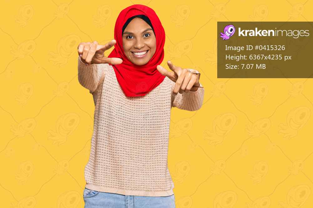 Young african american woman wearing traditional islamic hijab scarf pointing to you and the camera with fingers, smiling positive and cheerful 