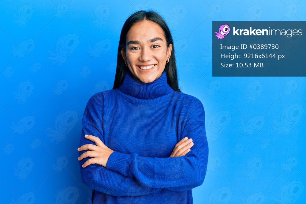 Young asian woman wearing casual winter sweater happy face smiling with crossed arms looking at the camera. positive person. 