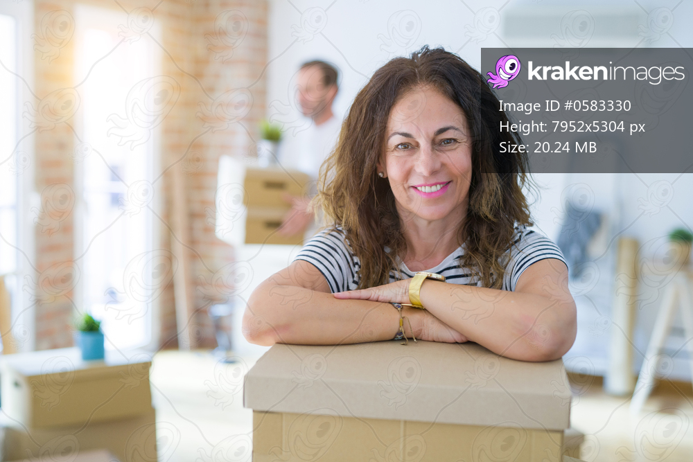 Middle age senior couple moving to a new house, woman smiling happy in love with new apartment