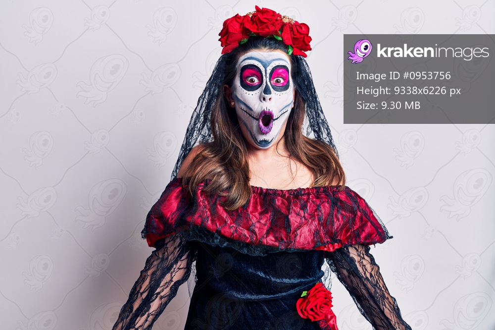 Young woman wearing day of the dead costume over white afraid and shocked with surprise and amazed expression, fear and excited face. 