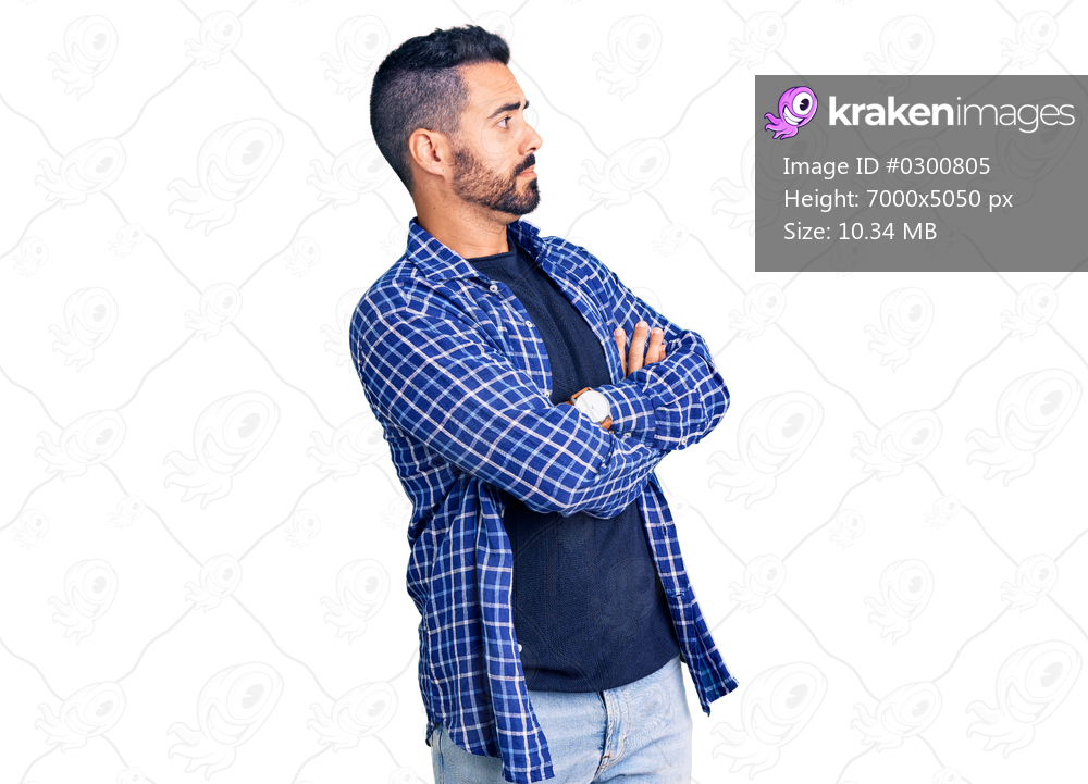 Young hispanic man wearing casual clothes looking to the side with arms crossed convinced and confident 