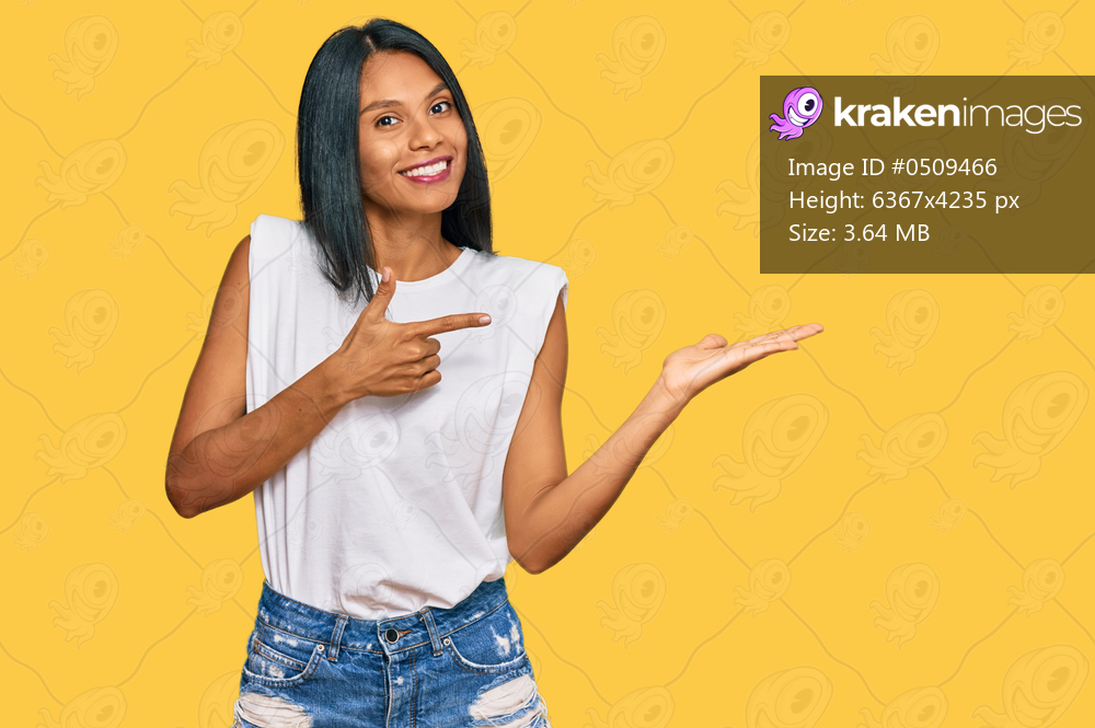 Young african american woman wearing casual clothes amazed and smiling to the camera while presenting with hand and pointing with finger. 