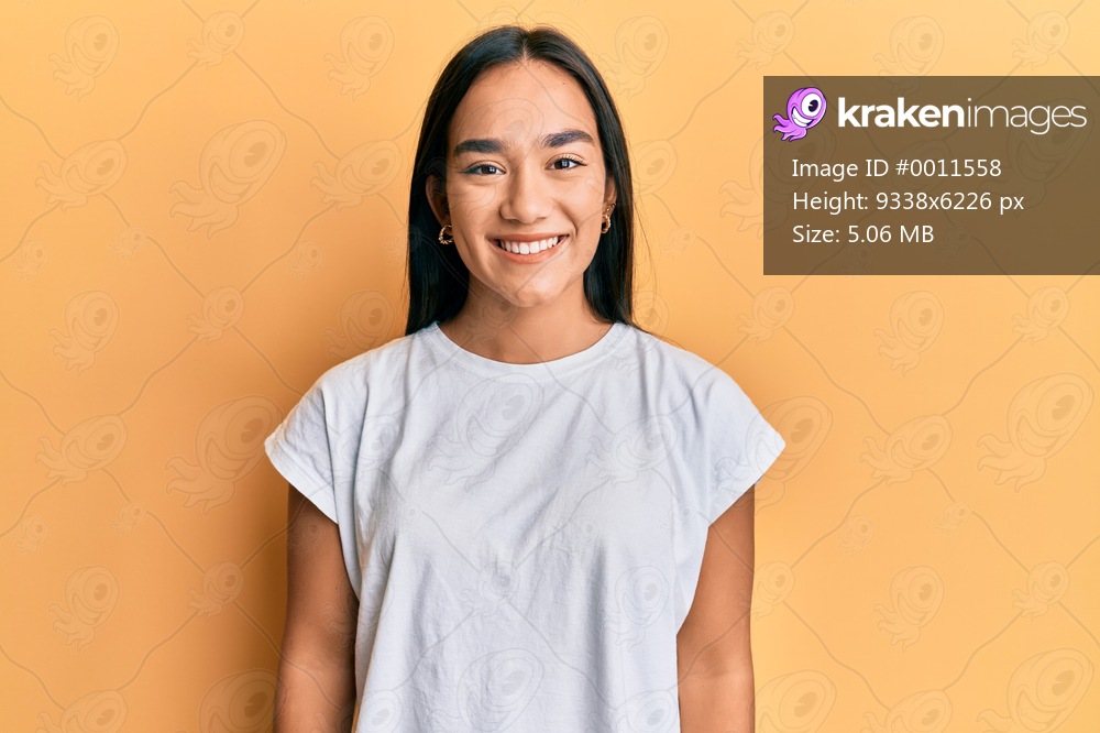 Young asian woman wearing casual white t shirt with a happy and cool smile on face. lucky person. 