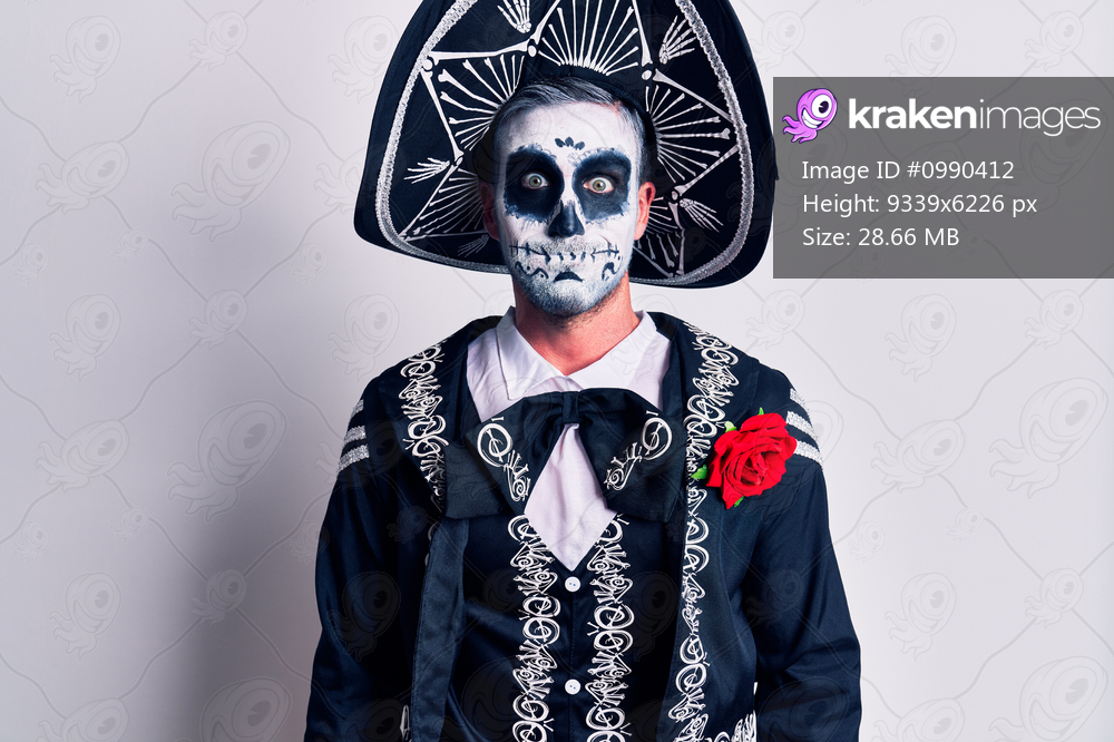 Young man wearing mexican day of the dead costume over white puffing cheeks with funny face. mouth inflated with air, crazy expression. 