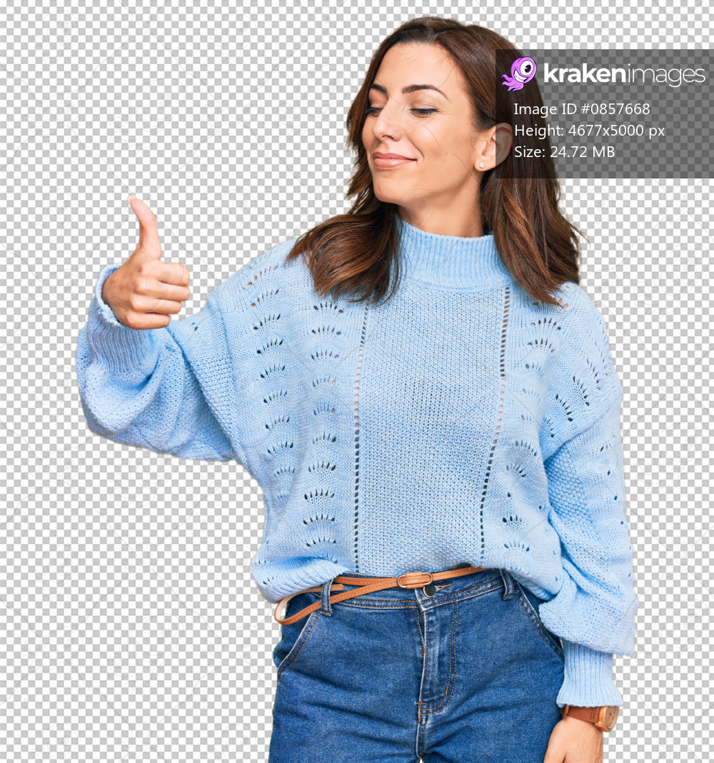 Young brunette woman wearing casual winter sweater looking proud, smiling doing thumbs up gesture to the side