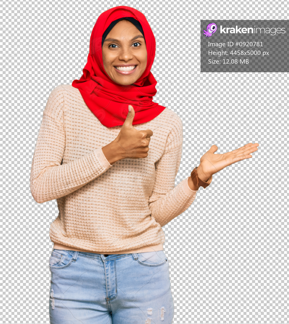 Young african american woman wearing traditional islamic hijab scarf showing palm hand and doing ok gesture with thumbs up, smiling happy and cheerful