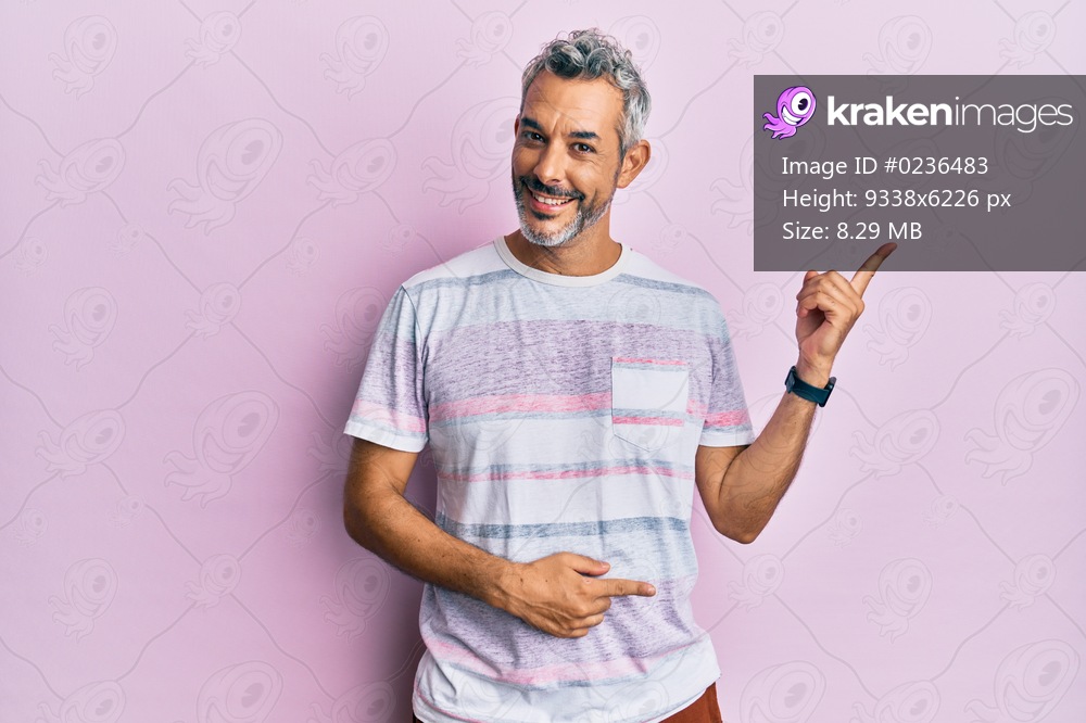 Middle age grey-haired man wearing casual clothes smiling happy pointing with hand and finger to the side 