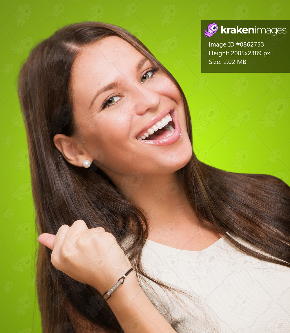 Portrait of a woman doing a success gesture against a green background