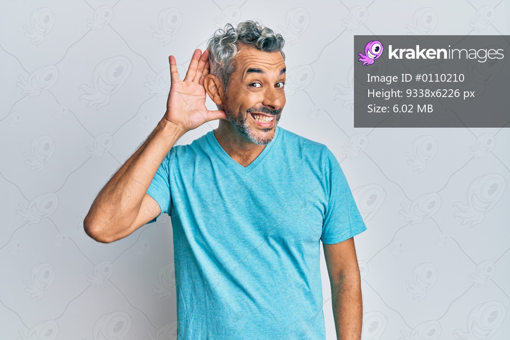 Middle age grey-haired man wearing casual clothes smiling with hand over ear listening an hearing to rumor or gossip. deafness concept. 