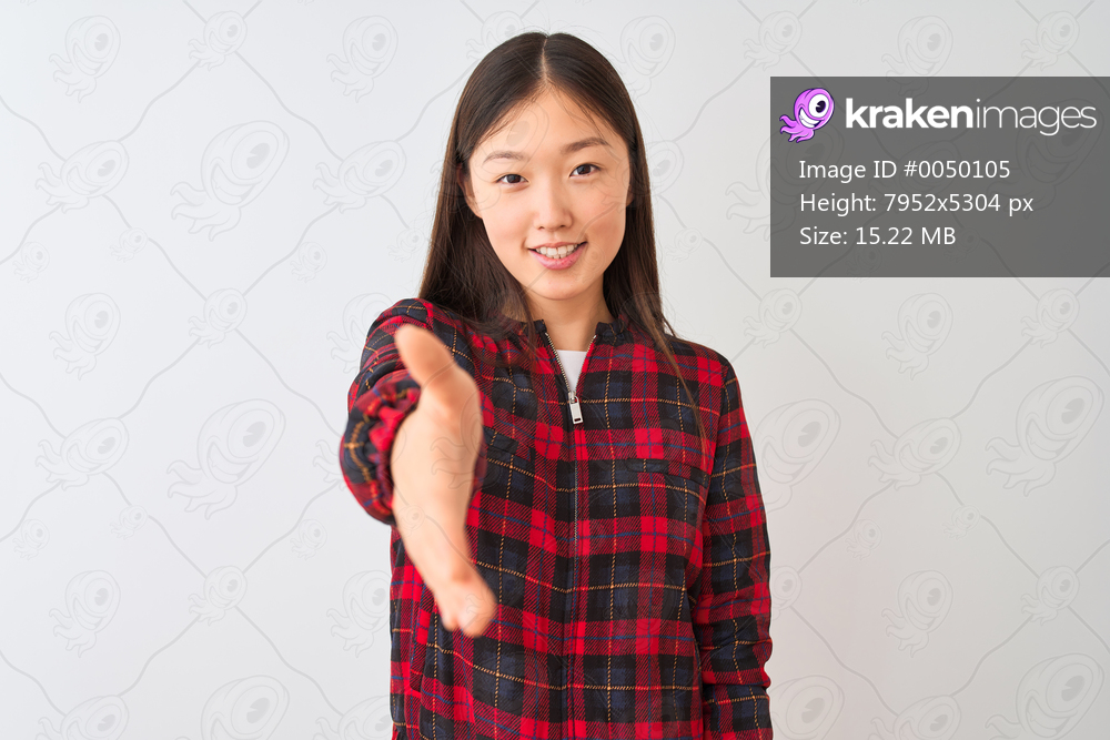 Young chinese woman wearing casual jacket standing over isolated white background smiling friendly offering handshake as greeting and welcoming. Successful business.