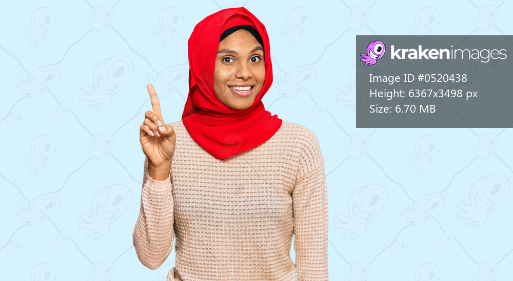 Young african american woman wearing traditional islamic hijab scarf pointing finger up with successful idea. exited and happy. number one. 