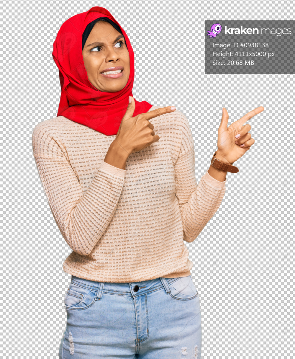 Young african american woman wearing traditional islamic hijab scarf pointing aside worried and nervous with both hands, concerned and surprised expression