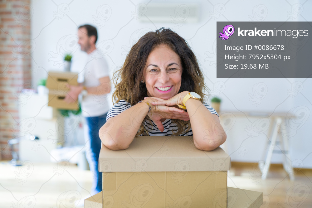 Middle age senior couple moving to a new house, woman smiling happy in love with new apartment
