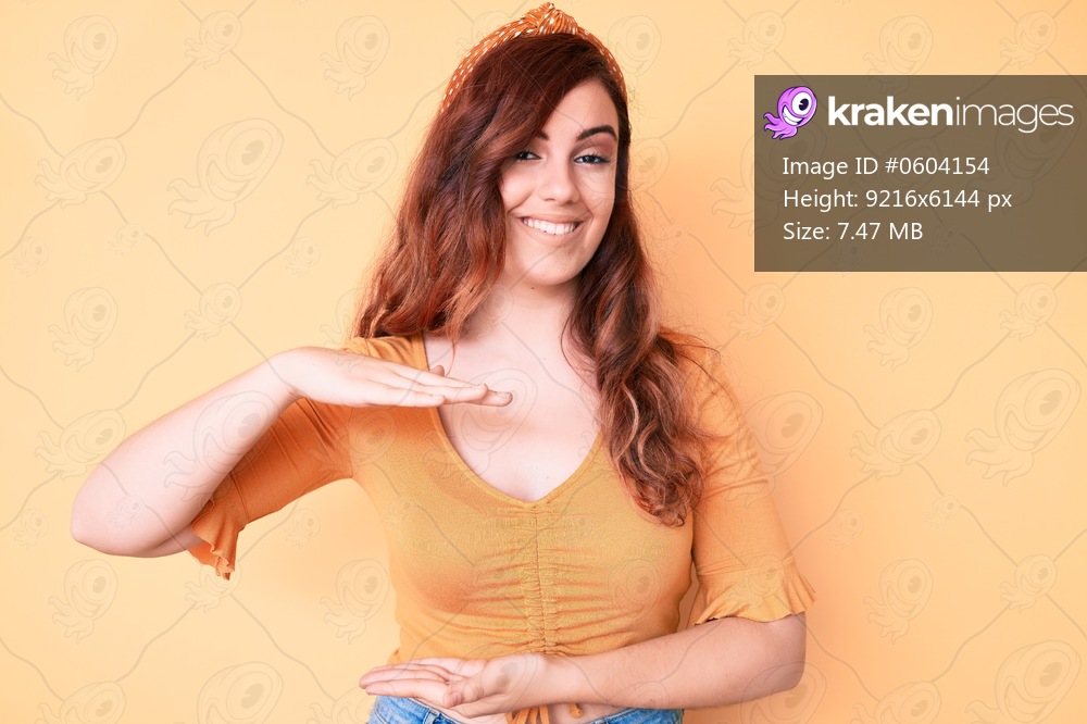 Young beautiful woman wearing casual clothes gesturing with hands showing big and large size sign, measure symbol. smiling looking at the camera. measuring concept. 