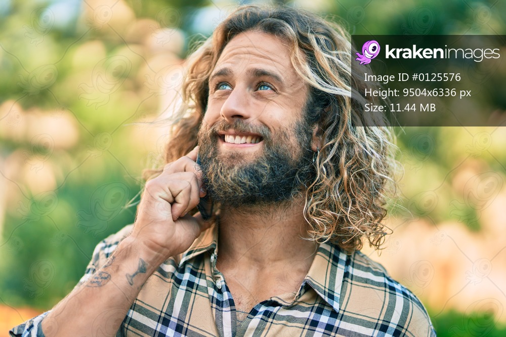 Young caucasian man smiling happy talking on the smartphone at the park.