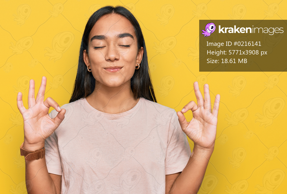 Young asian woman wearing casual clothes relax and smiling with eyes closed doing meditation gesture with fingers. yoga concept. 