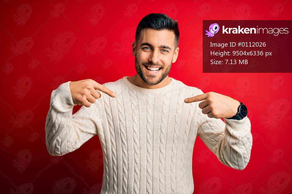 Young handsome man wearing casual white sweater standing over isolated red background looking confident with smile on face, pointing oneself with fingers proud and happy.
