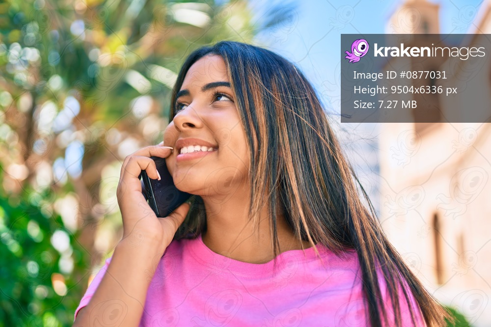Young latin woman smiling happy talking on the smartphone at the park.