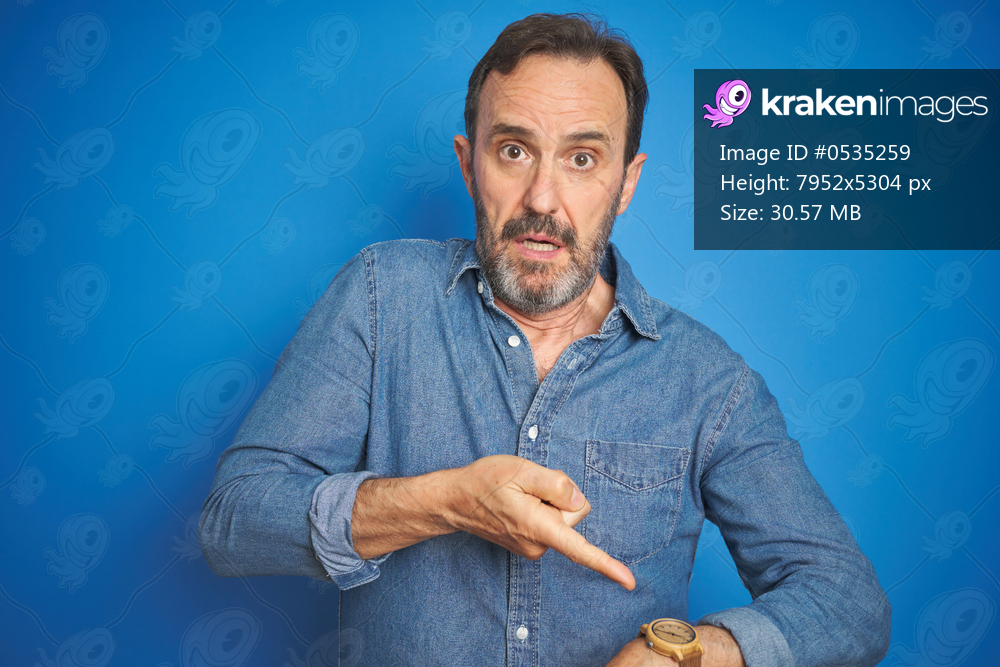 Handsome middle age senior man with grey hair over isolated blue background In hurry pointing to watch time, impatience, upset and angry for deadline delay