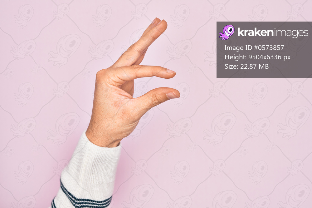 Hand of caucasian young man showing fingers over isolated pink background picking and taking invisible thing, holding object with fingers showing space