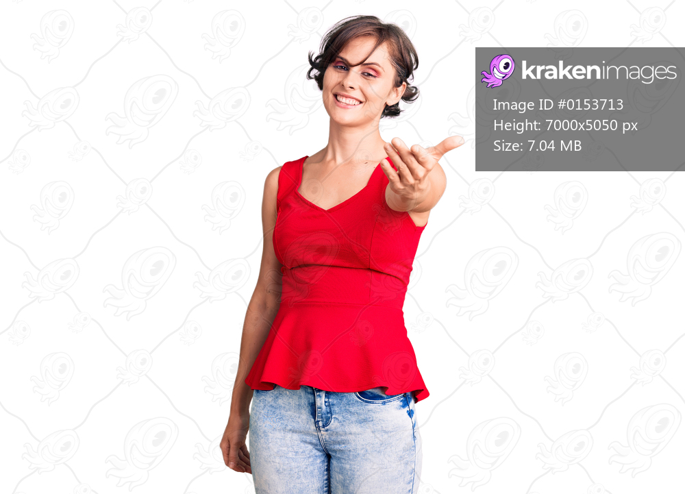 Beautiful young woman with short hair wearing casual style with sleeveless shirt smiling cheerful offering palm hand giving assistance and acceptance. 