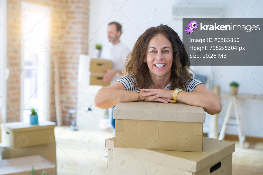 Middle age senior couple moving to a new house, woman smiling happy in love with new apartment