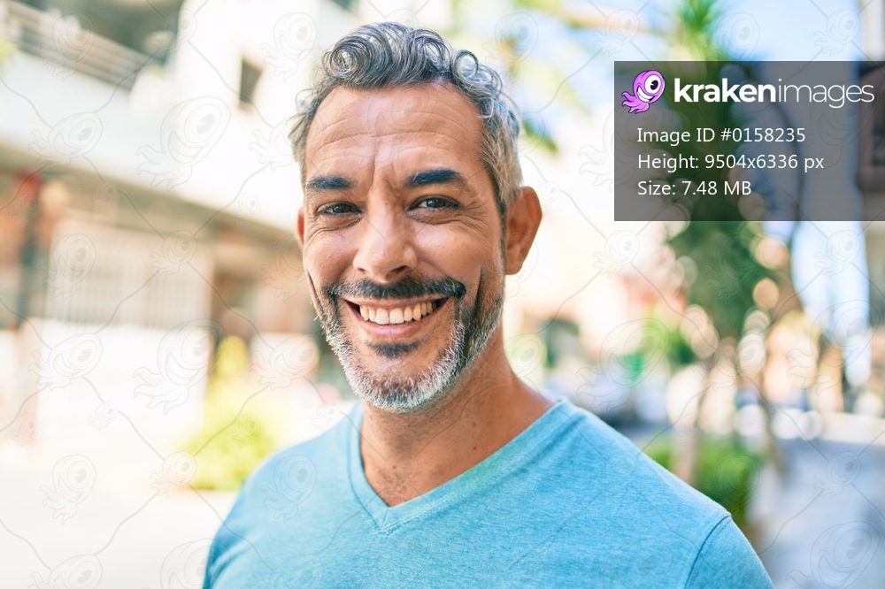 Middle age grey-haired man smiling happy walking at street of city.