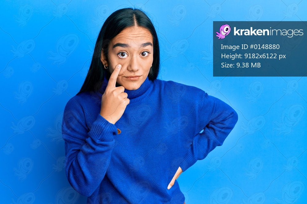 Young asian woman wearing casual winter sweater pointing to the eye watching you gesture, suspicious expression 