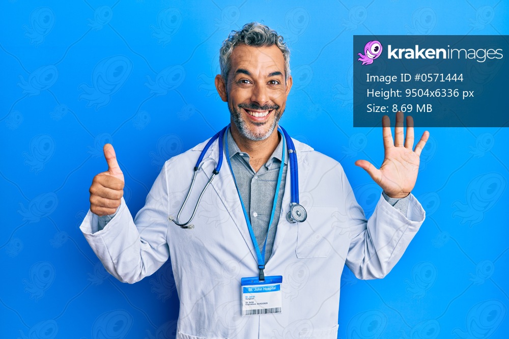 Middle age grey-haired man wearing doctor uniform and stethoscope showing and pointing up with fingers number six while smiling confident and happy. 