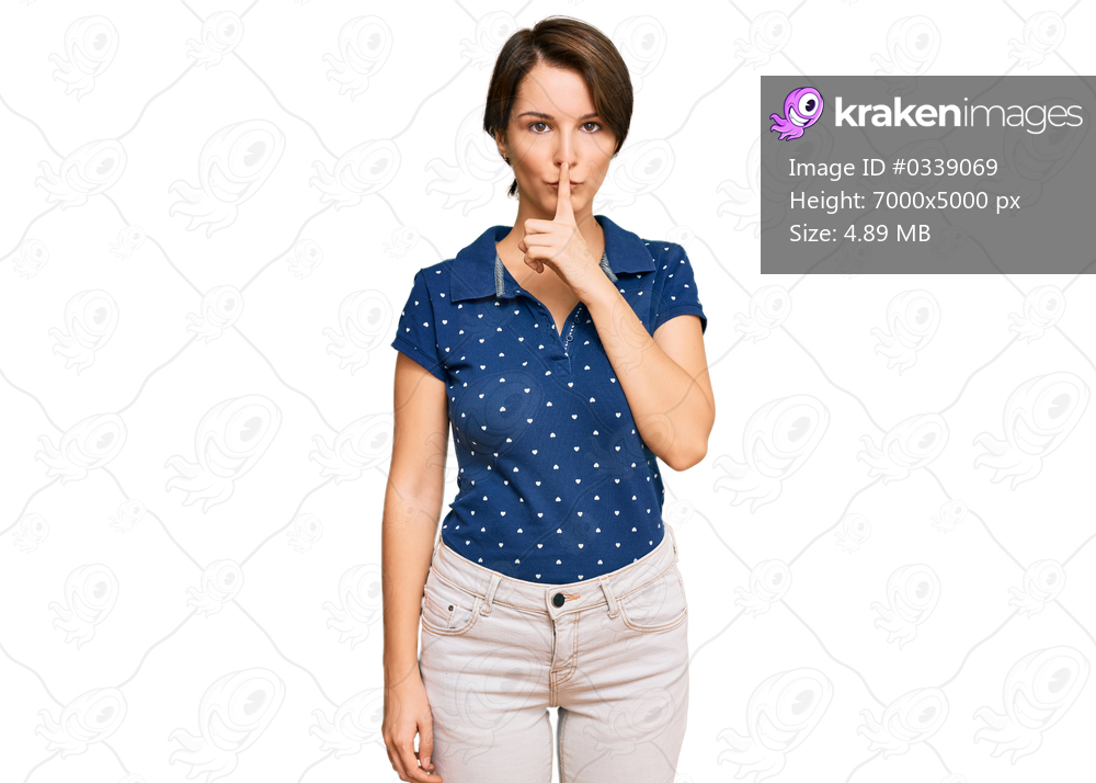 Young brunette woman with short hair wearing casual clothes asking to be quiet with finger on lips. silence and secret concept. 