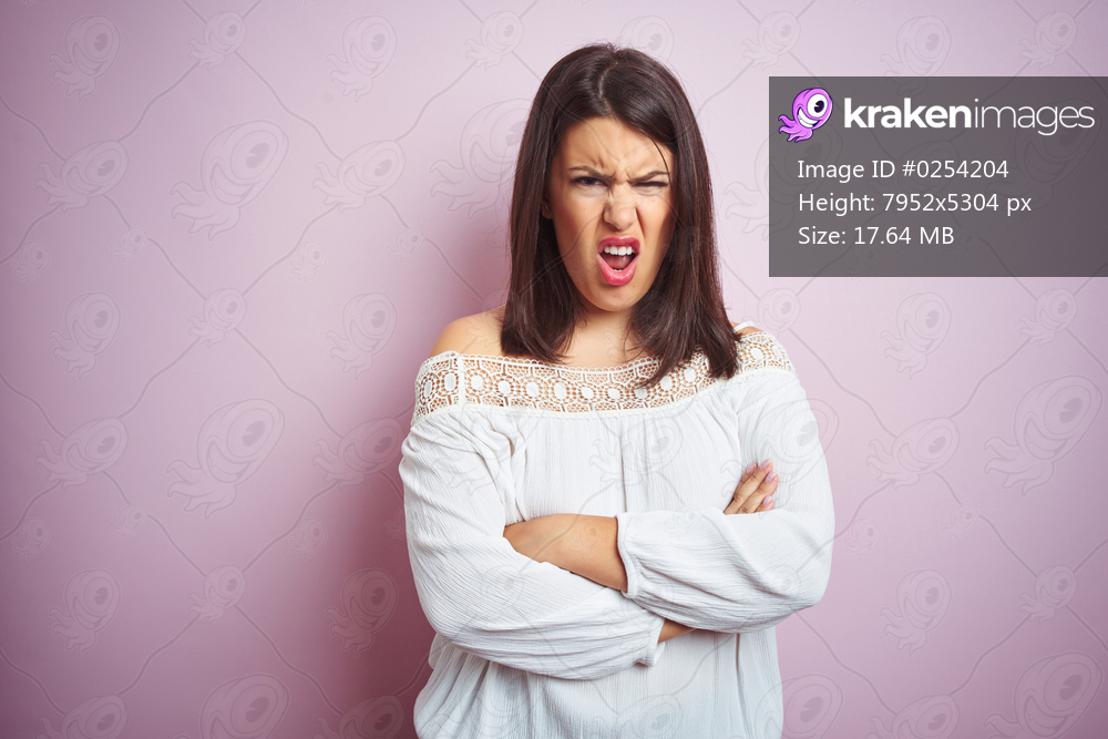 Young beautiful brunette woman over pink isolated background skeptic and nervous, disapproving expression on face with crossed arms. Negative person.