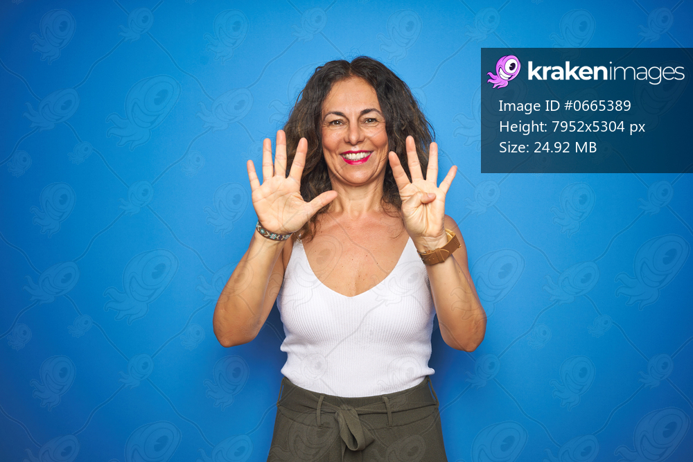 Middle age senior woman with curly hair standing over blue isolated background showing and pointing up with fingers number nine while smiling confident and happy.