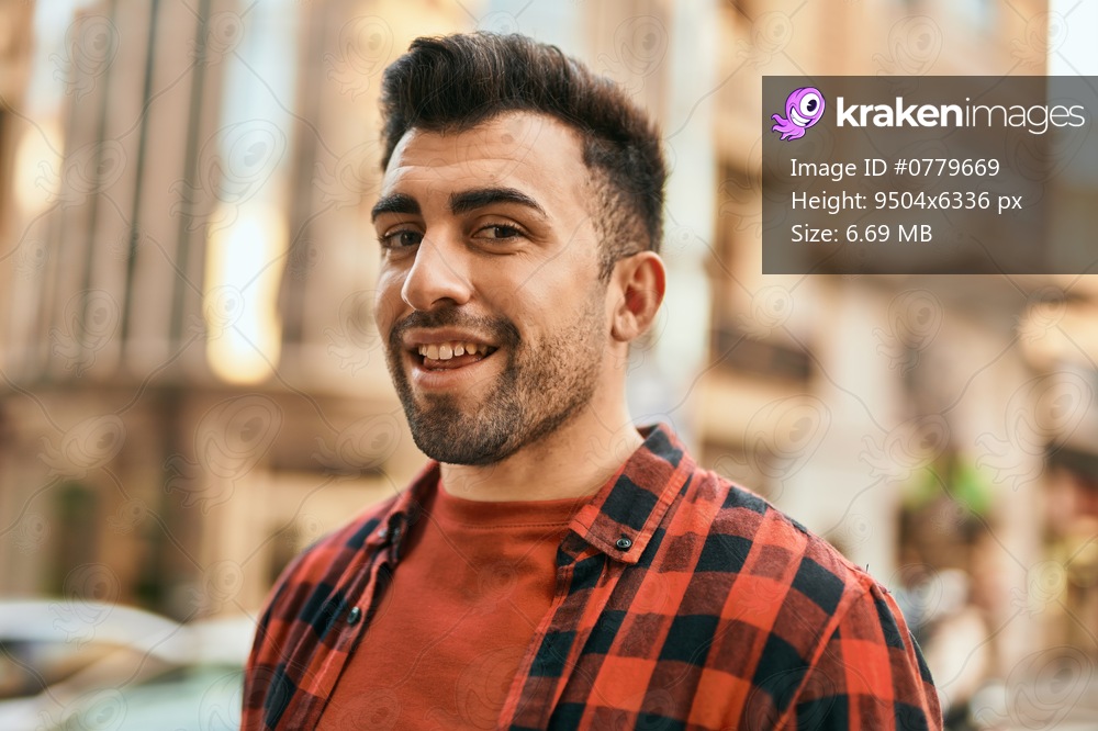 Young hispanic man smiling happy standing at the city.