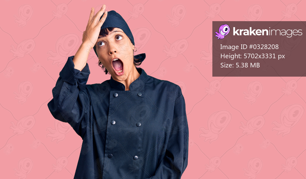 Young brunette woman with short hair wearing professional cook uniform surprised with hand on head for mistake, remember error. forgot, bad memory concept. 