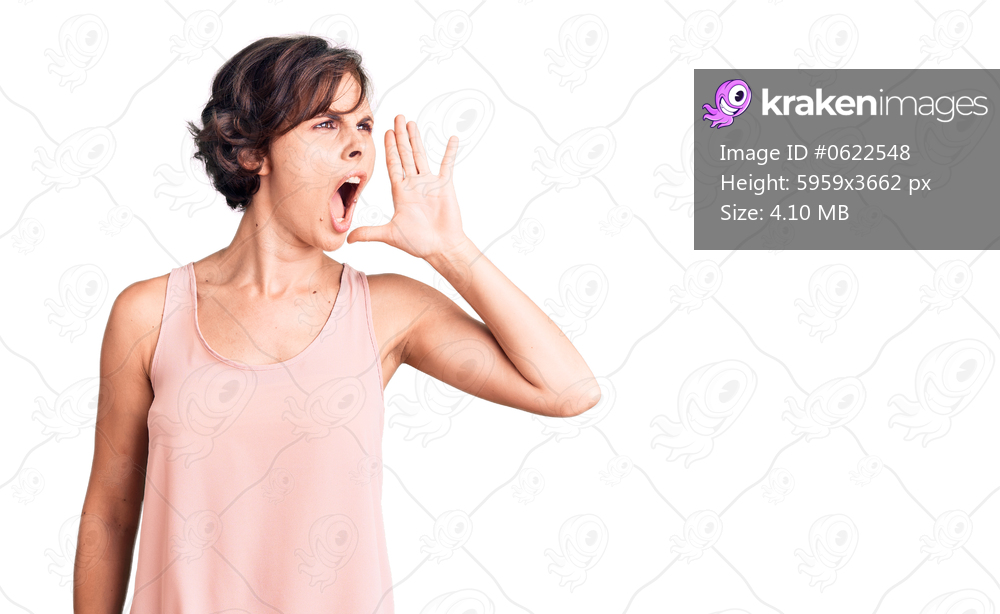 Beautiful young woman with short hair wearing casual style with sleeveless shirt shouting and screaming loud to side with hand on mouth. communication concept. 