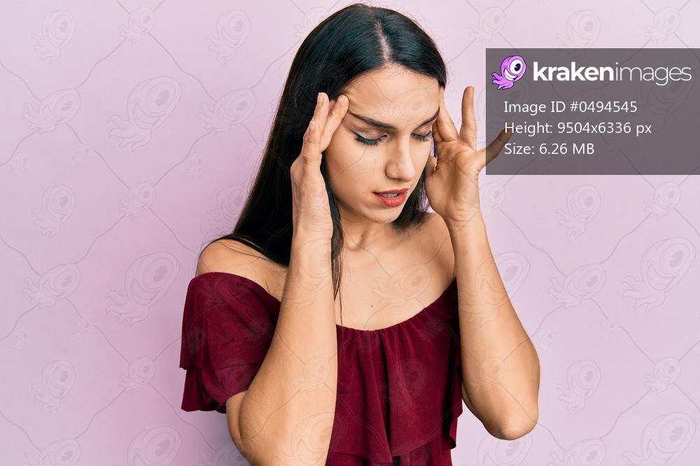 Young hispanic woman wearing casual clothes with hand on head for pain in head because stress. suffering migraine. 