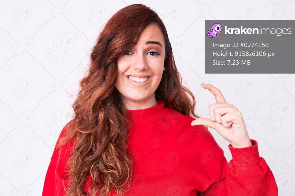 Young beautiful woman wearing casual clothes smiling and confident gesturing with hand doing small size sign with fingers looking and the camera. measure concept. 