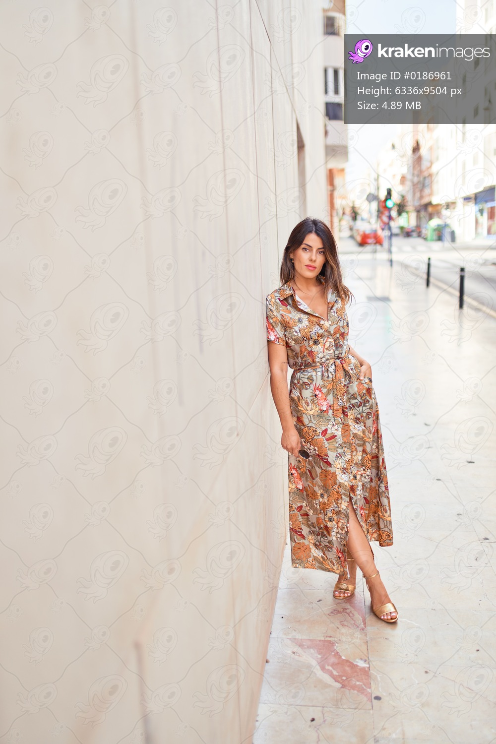 Beautiful young woman wearing fashionable clothes walking down the street