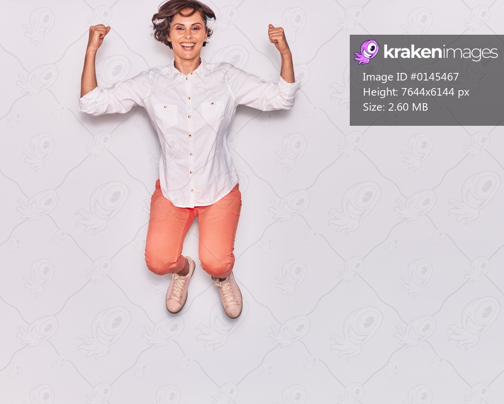 Young beautiful woman wearing casual clothes smiling happy. Jumping with smile on face celebrating with fists up over isolated white background.