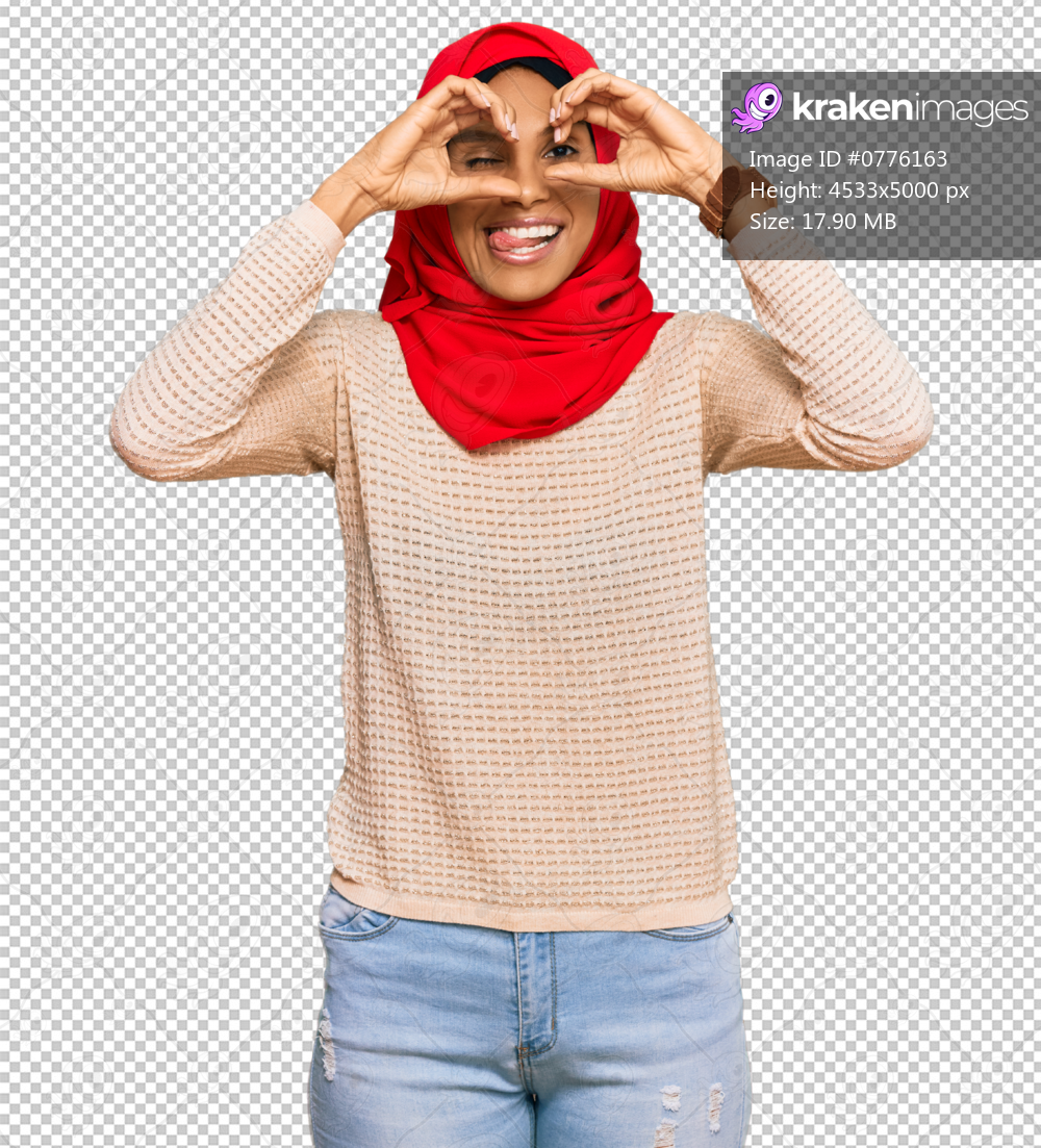 Young african american woman wearing traditional islamic hijab scarf doing ok gesture like binoculars sticking tongue out, eyes looking through fingers. crazy expression.