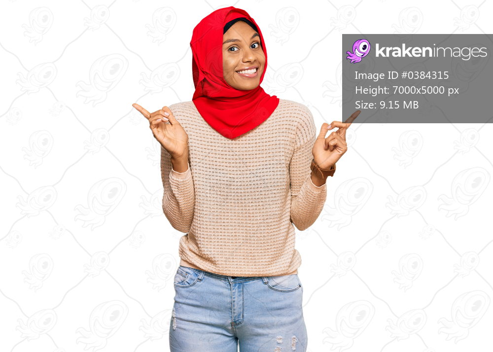 Young african american woman wearing traditional islamic hijab scarf smiling confident pointing with fingers to different directions. copy space for advertisement 
