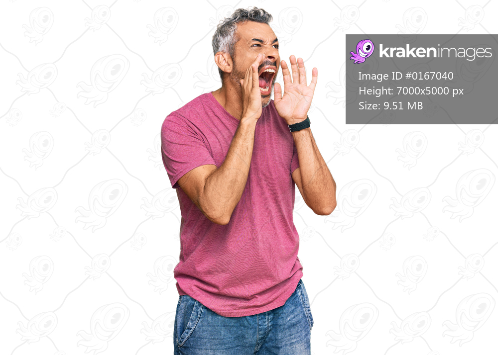 Middle age grey-haired man wearing casual clothes shouting angry out loud with hands over mouth 