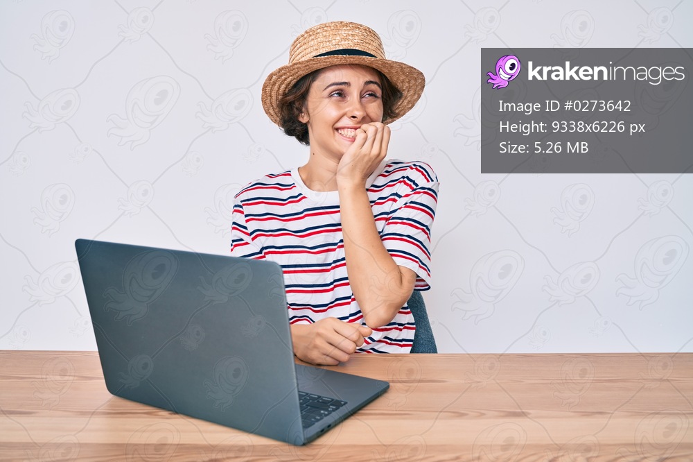 Young hispanic woman working with laptop sitting on the table looking stressed and nervous with hands on mouth biting nails. anxiety problem. 