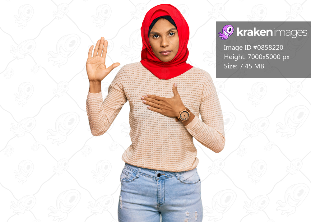 Young african american woman wearing traditional islamic hijab scarf swearing with hand on chest and open palm, making a loyalty promise oath 