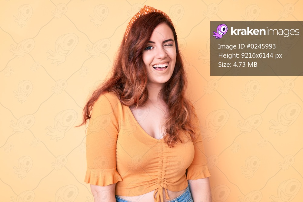 Young beautiful woman wearing casual clothes winking looking at the camera with sexy expression, cheerful and happy face. 