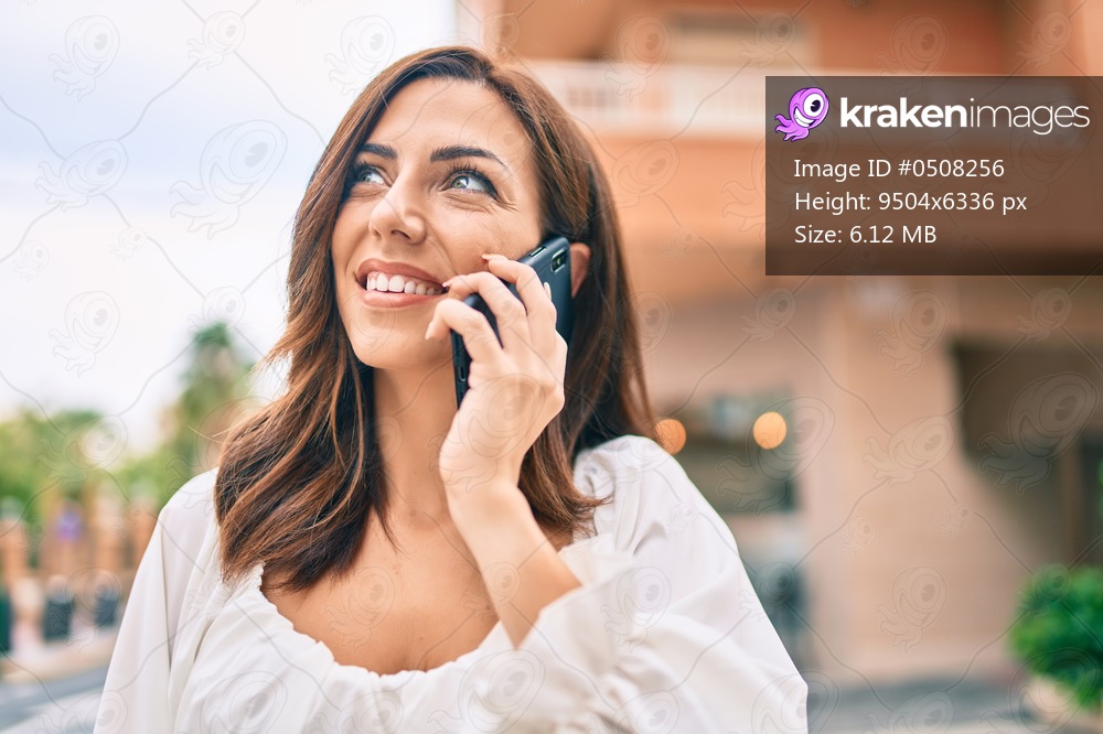 Young hispanic woman smiling happy talking on the smartphone at the city.