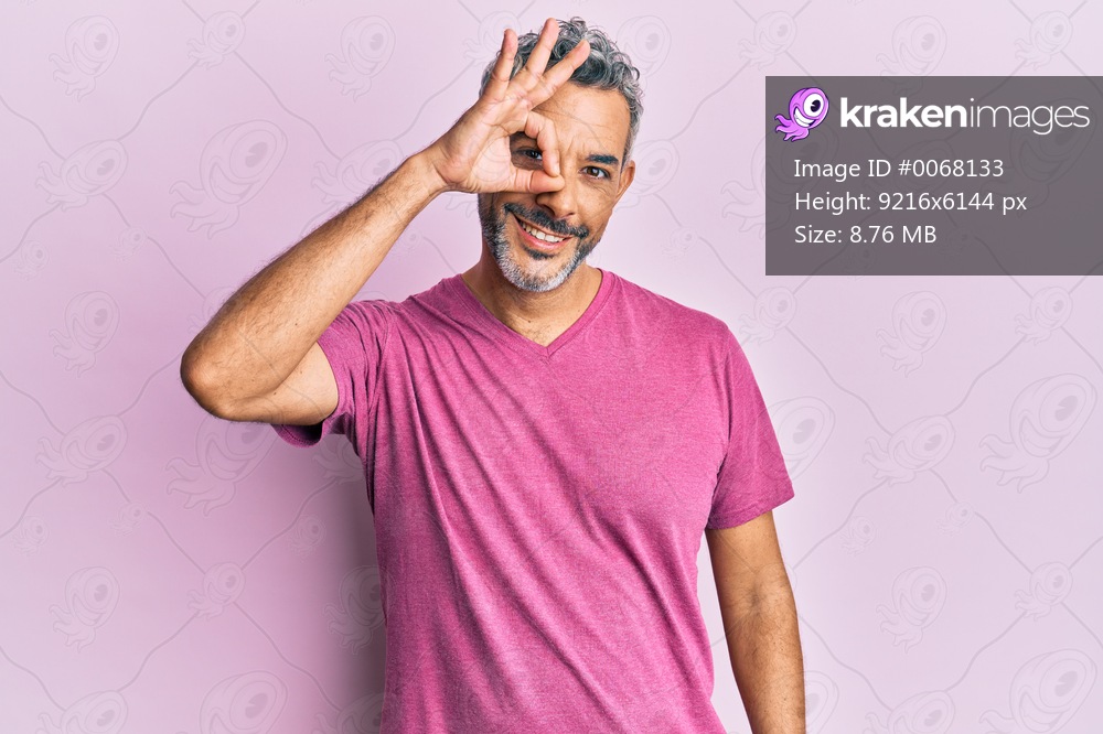 Middle age grey-haired man wearing casual clothes smiling happy doing ok sign with hand on eye looking through fingers 