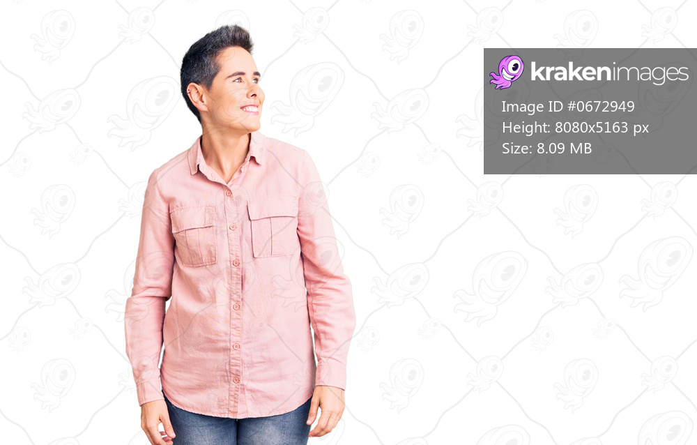 Young woman with short hair wearing casual clothes looking away to side with smile on face, natural expression. laughing confident. 