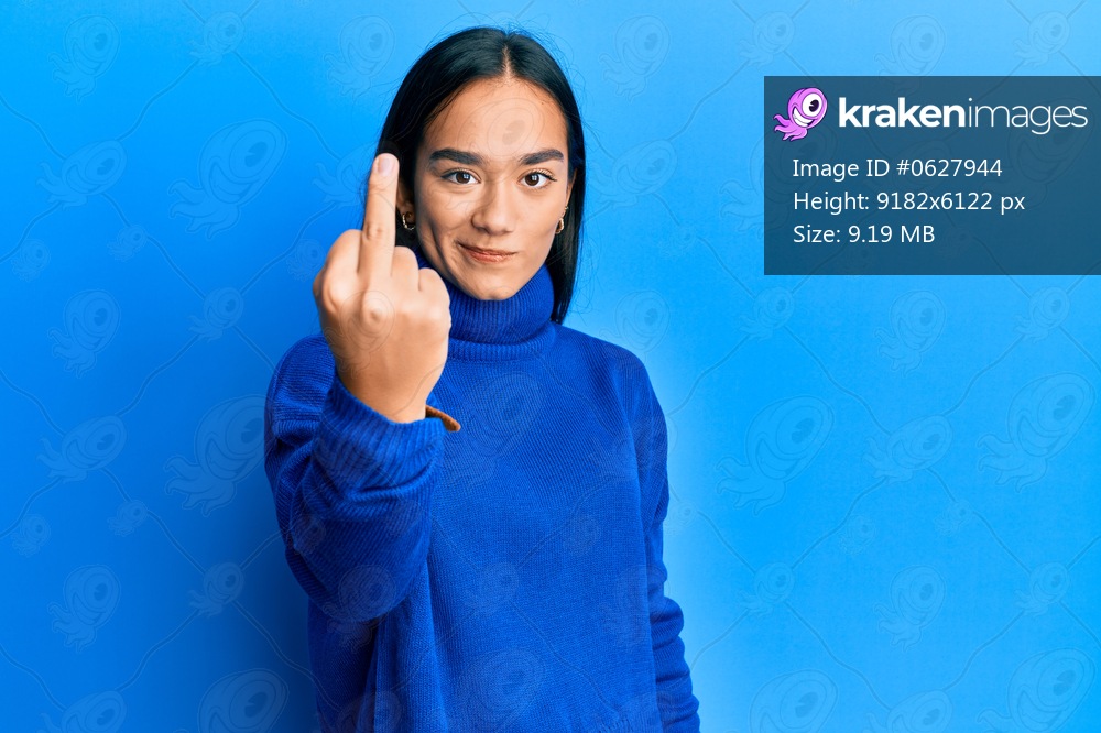Young asian woman wearing casual winter sweater showing middle finger, impolite and rude fuck off expression 
