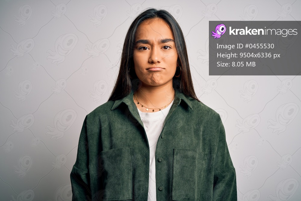 Young beautiful asian woman wearing casual shirt standing over isolated white background depressed and worry for distress, crying angry and afraid. Sad expression.